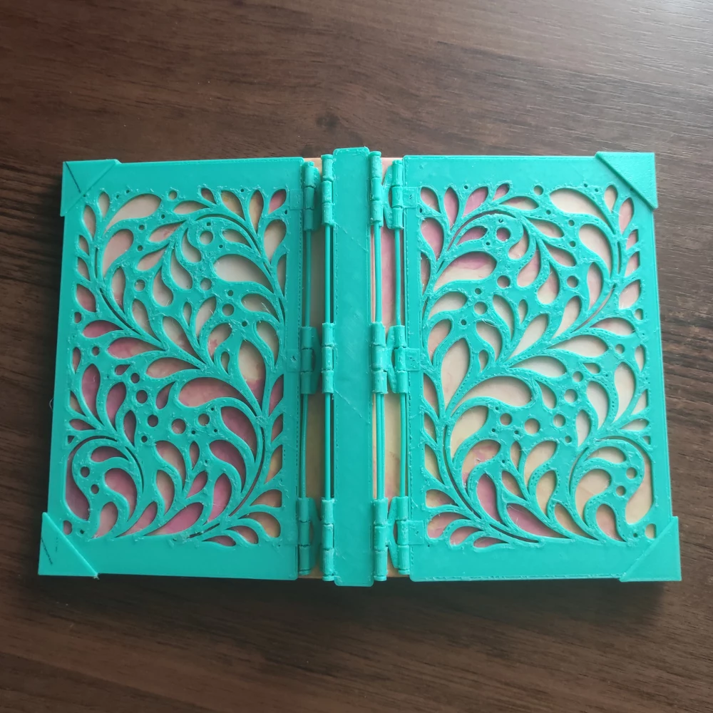 Open CoverForge notebook cover showing both printed panels, spine and filament hinge axles