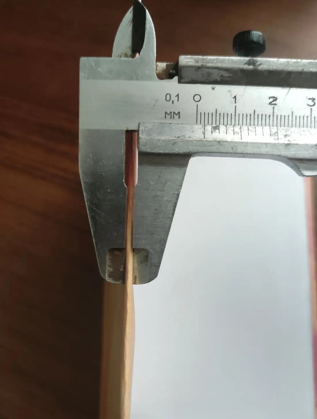 Calipers measuring one rigid notebook cover at 1.8 millimeters thick